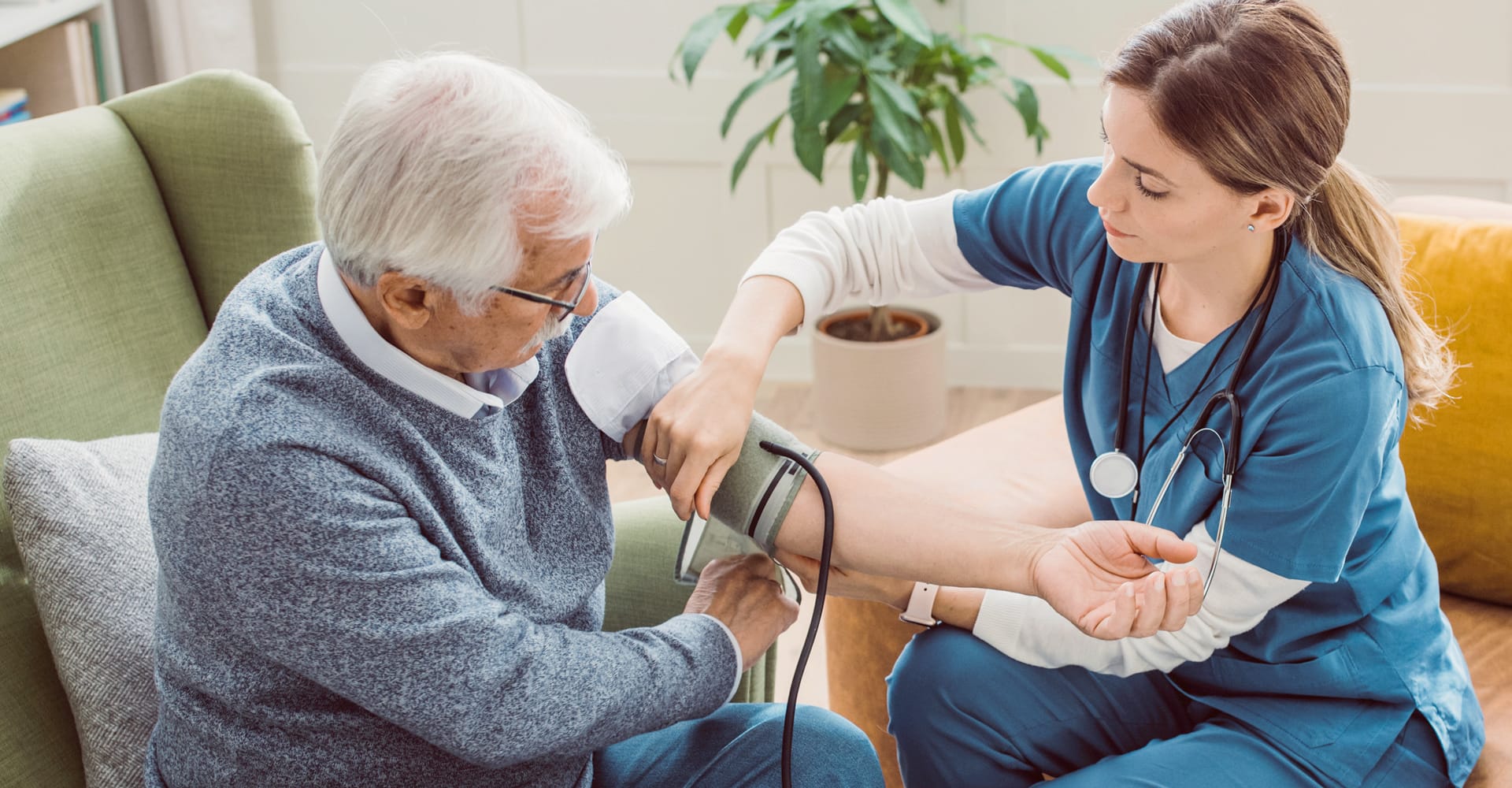 A health care provider checking the blood pressure of a senior patient