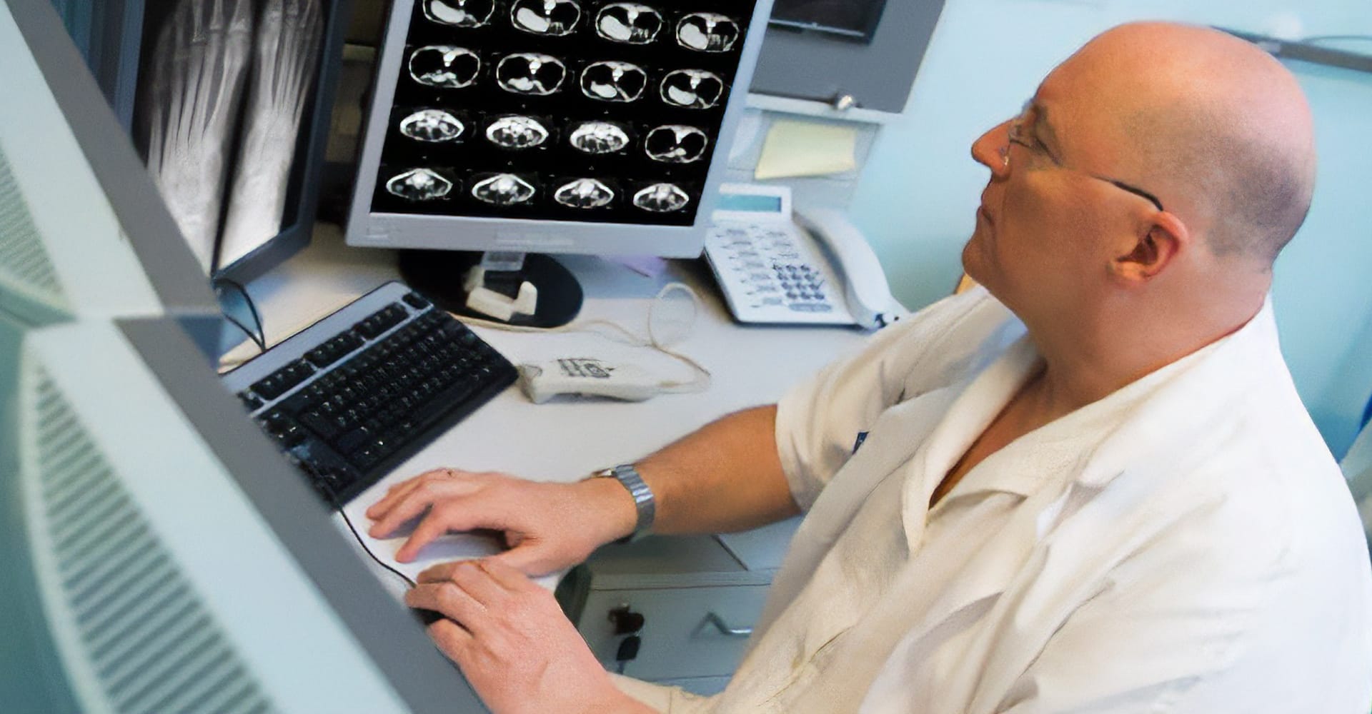 A health care provider examining various scans on computer screens