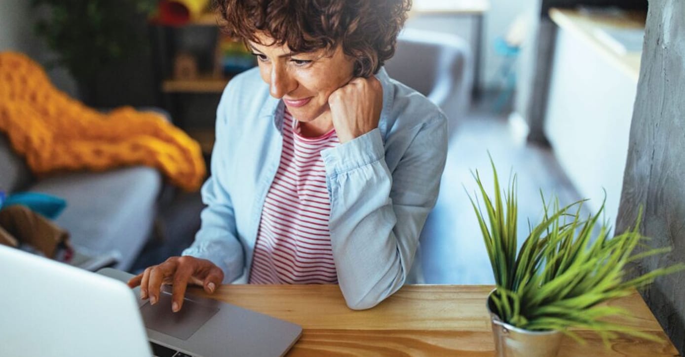 A person in a home setting using their laptop computer