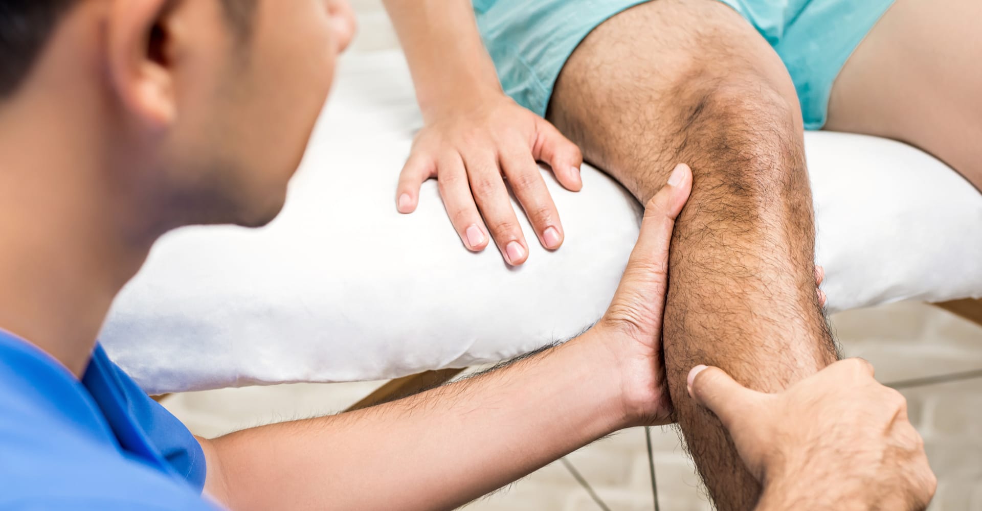 A health care provider examining the leg of a seated patient